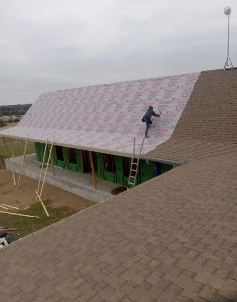 Worker preparing underlayment for a metal roof installation in Millersville